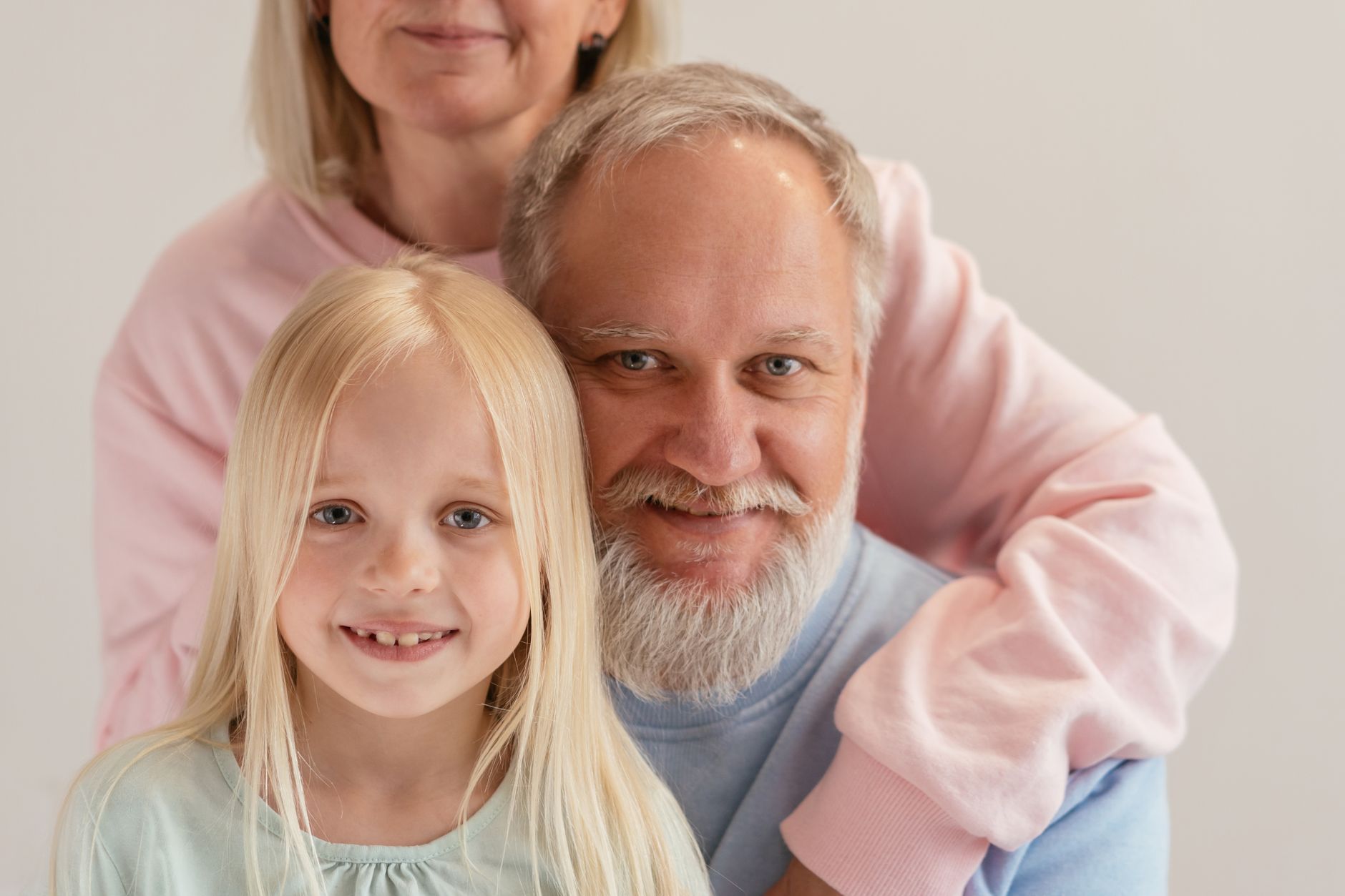 Three generations coming together with warmth and smiles in a studio setting.
