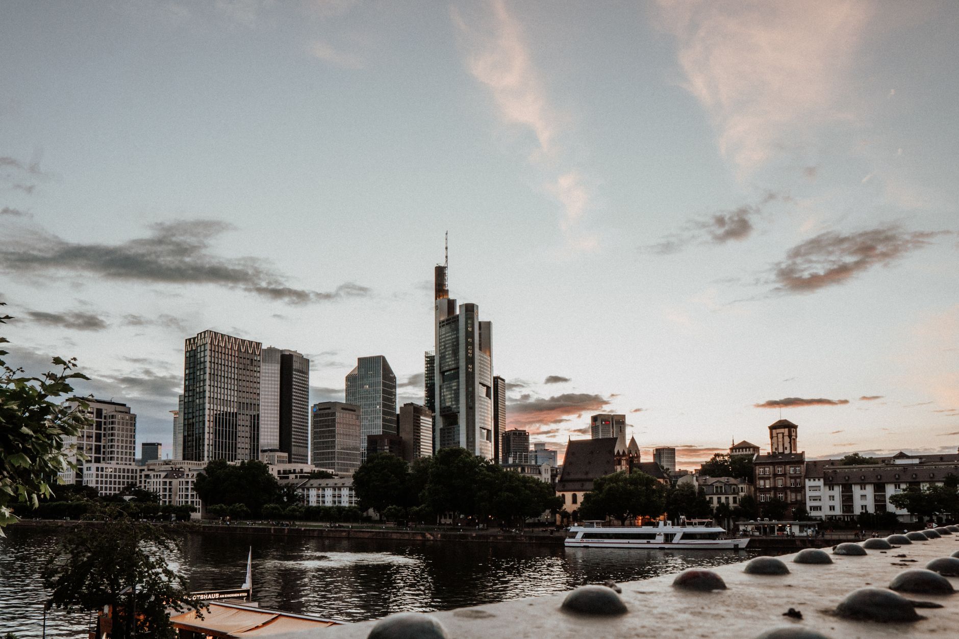 Frankfurt's modern skyline reflected in river at sunset, Germany.