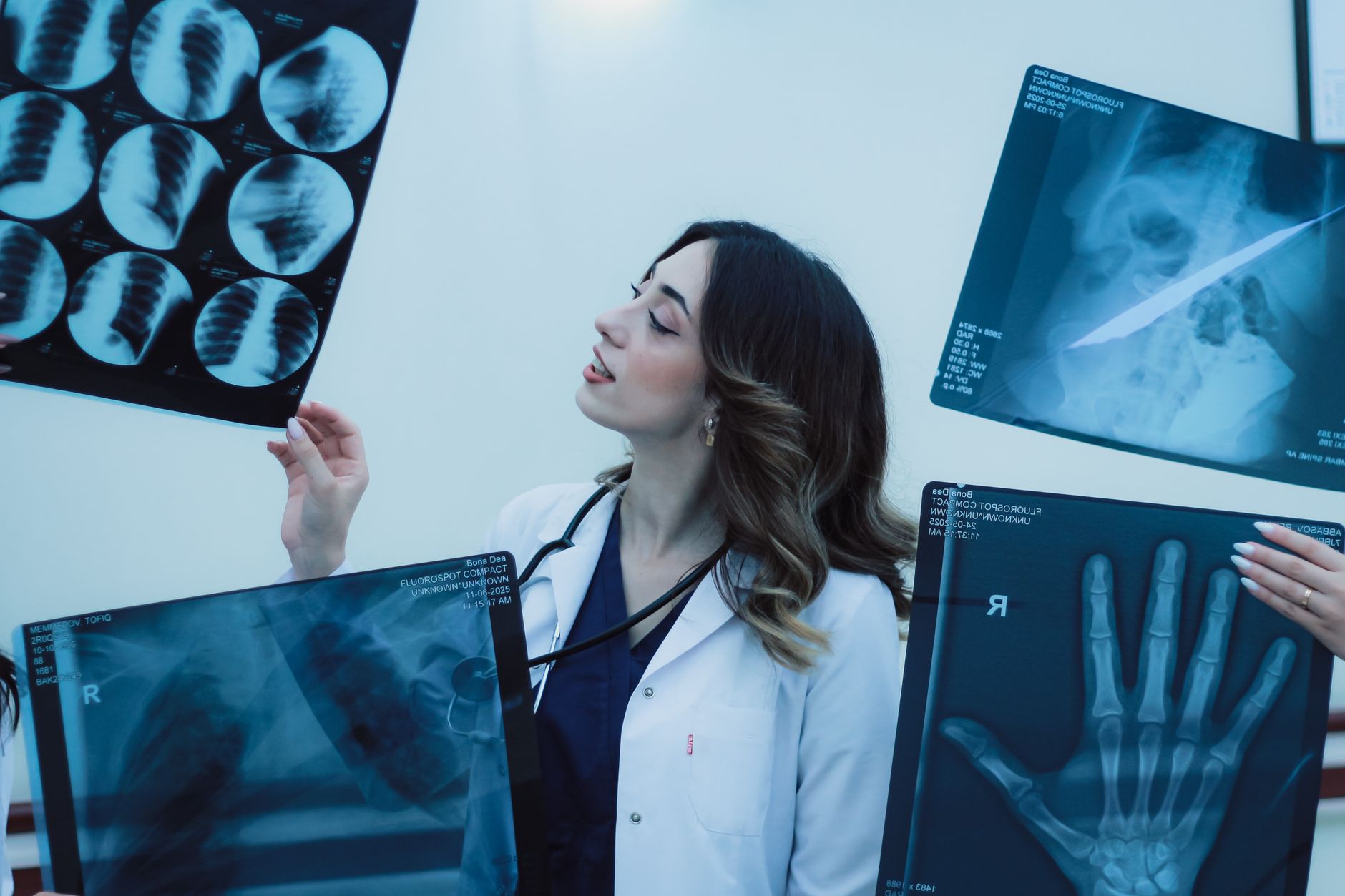 Female doctor examining X-rays in a clinical setting, showcasing medical expertise.