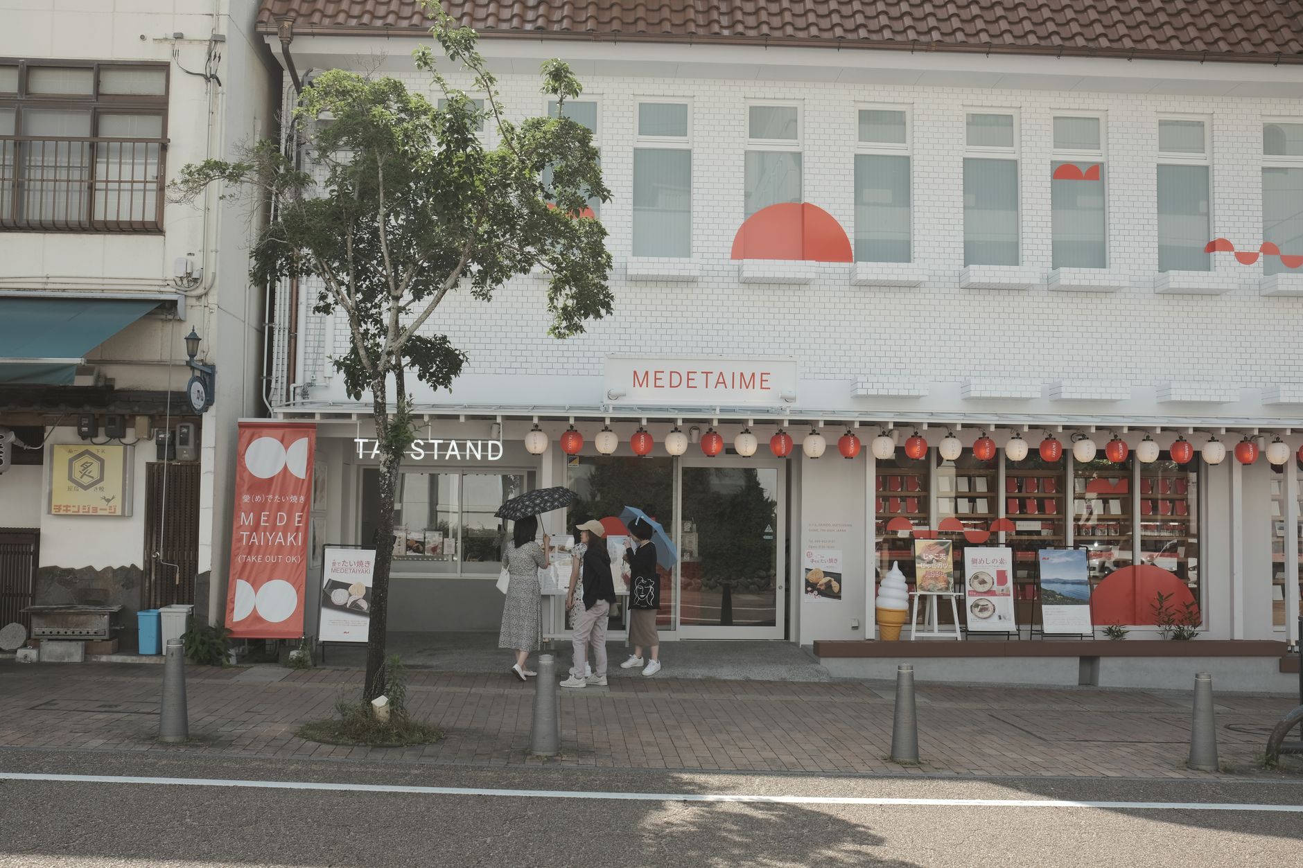Exterior view of a lively taiyaki shop, Medetaime, with visitors enjoying the street atmosphere.