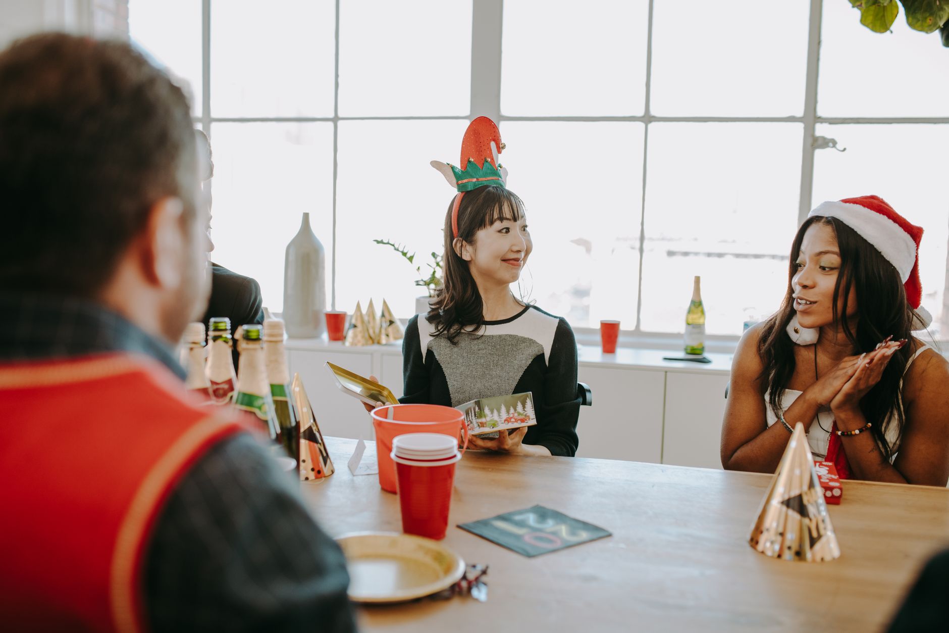 Colleagues at a holiday office party enjoying gifts and festive decorations.