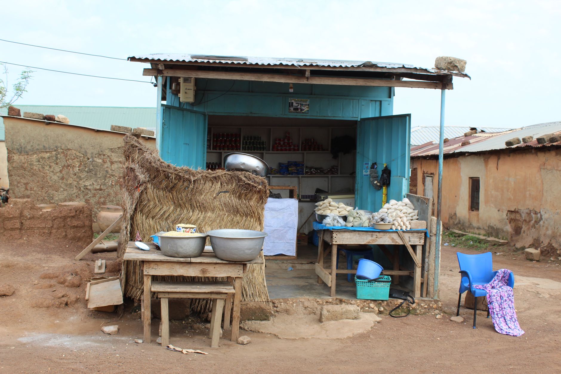 A quaint village store with traditional architecture displaying local goods in a rural setting.